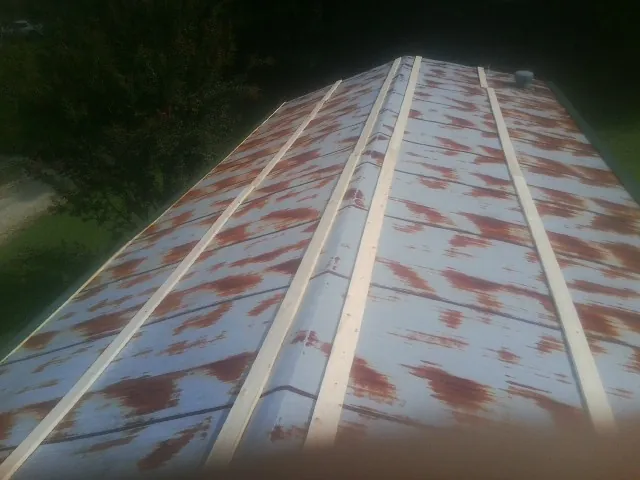 Rusted metal roof panels with new wood purlins before replacement — Storm Damage Roof Repair in Rantoul by Roofing Brothers