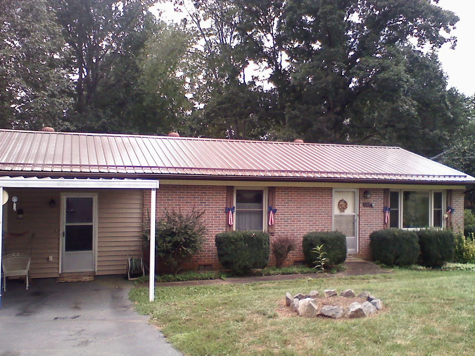 Bronze metal roof and carport on a brick ranch home in Rantoul