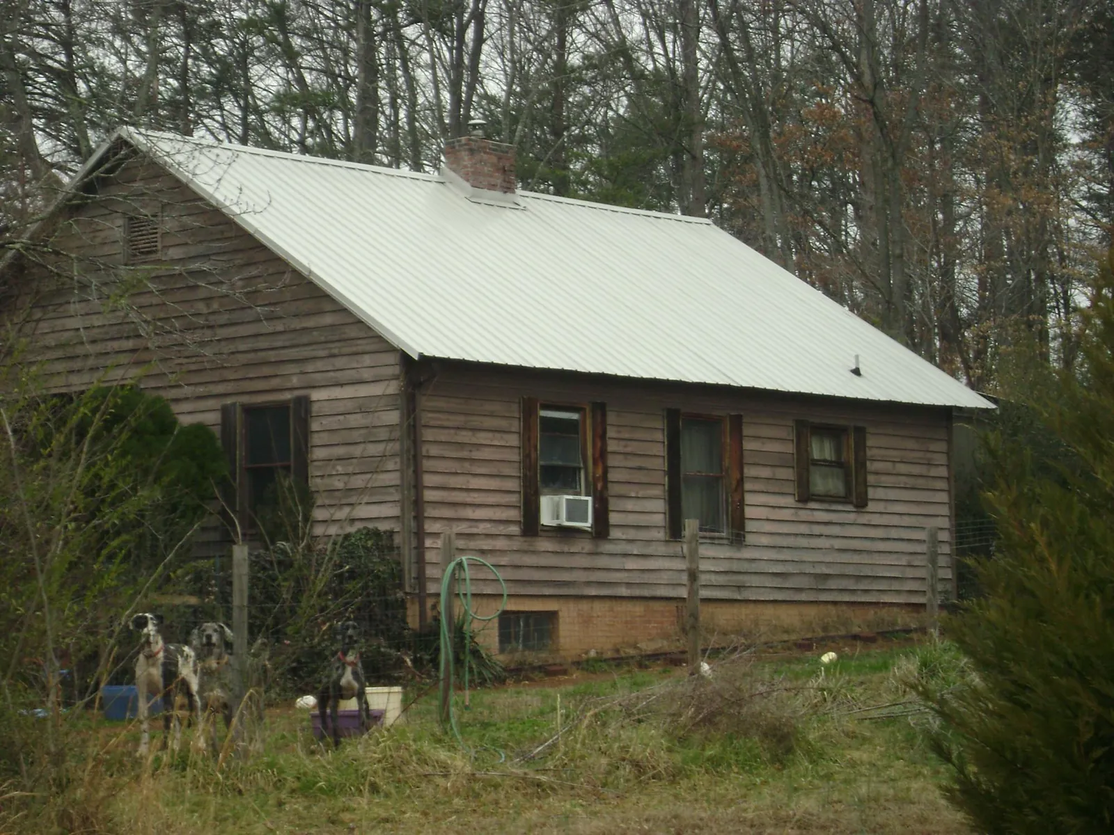White metal roof on an old wood sided farmhouse, from a Metal Roof Installation job in Rantoul